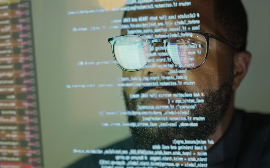Developer reviewing code on screen as part of an IBM i DevOps pipeline.
