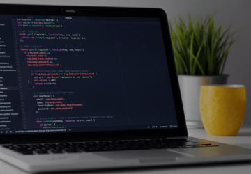 Developer coding JavaScript on laptop representing Eradani's modern IBM i integration and API development capabilities