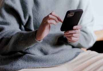 Person using smartphone for text messaging representing AI-powered customer service and IBM i integration solutions