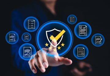 Hand pointing to compliance shield icon with document checklist symbols