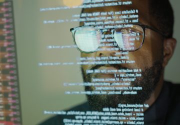 Developer reviewing code on screen as part of an IBM i DevOps pipeline.